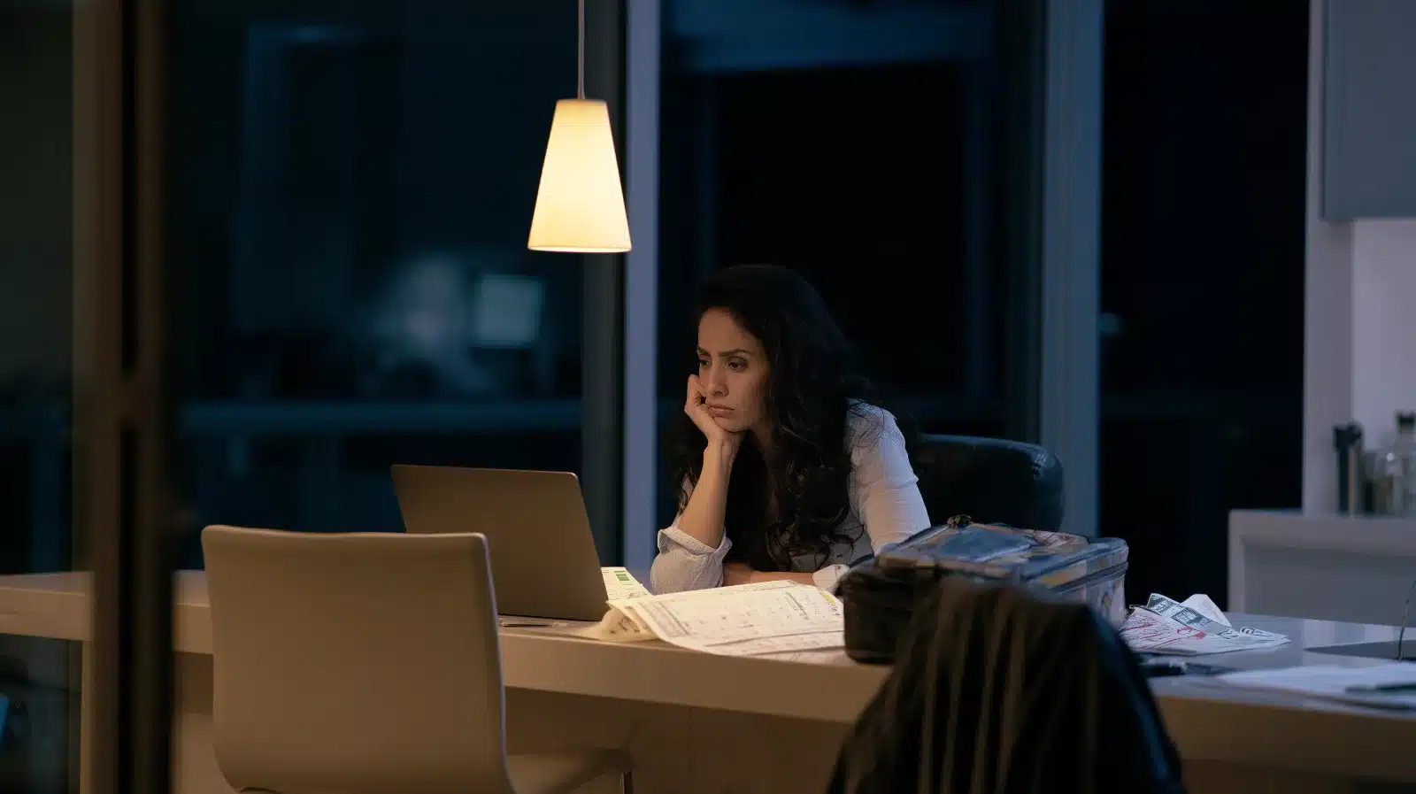 Woman updating the family calendar alone at night in her Fort Lauderdale kitchen, a common pattern when ADHD affects a relationship
