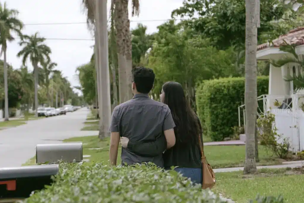 A couple walking together toward their home on a palm-lined Victoria Park street in Fort Lauderdale