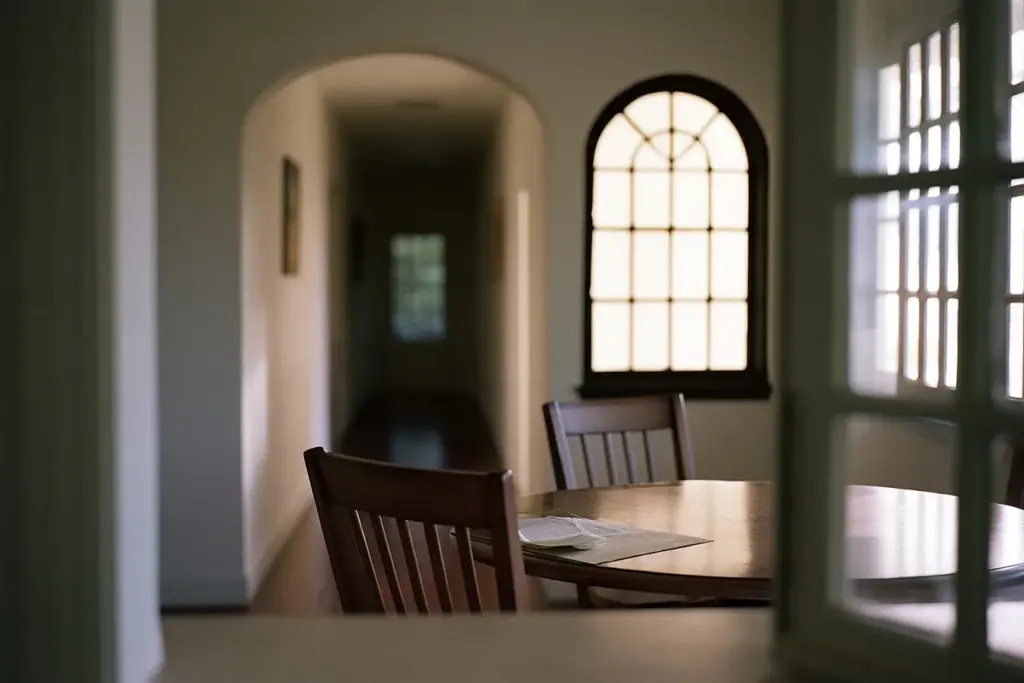 An empty kitchen table in a Coral Gables home with chairs pushed in and soft morning light