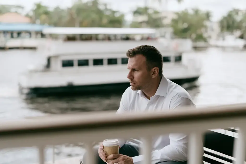 A man sitting alone on a bench along the Riverwalk in downtown Fort Lauderdale, thoughtful