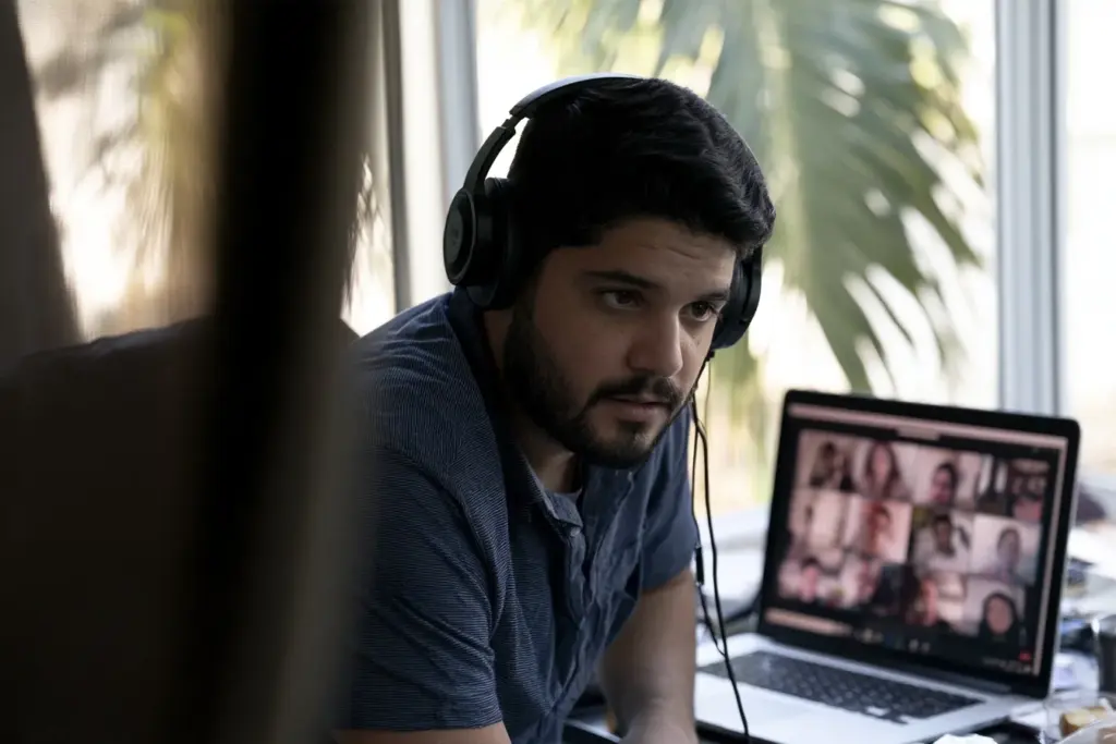 A man attentively participating in an online men's group from his South Florida home office