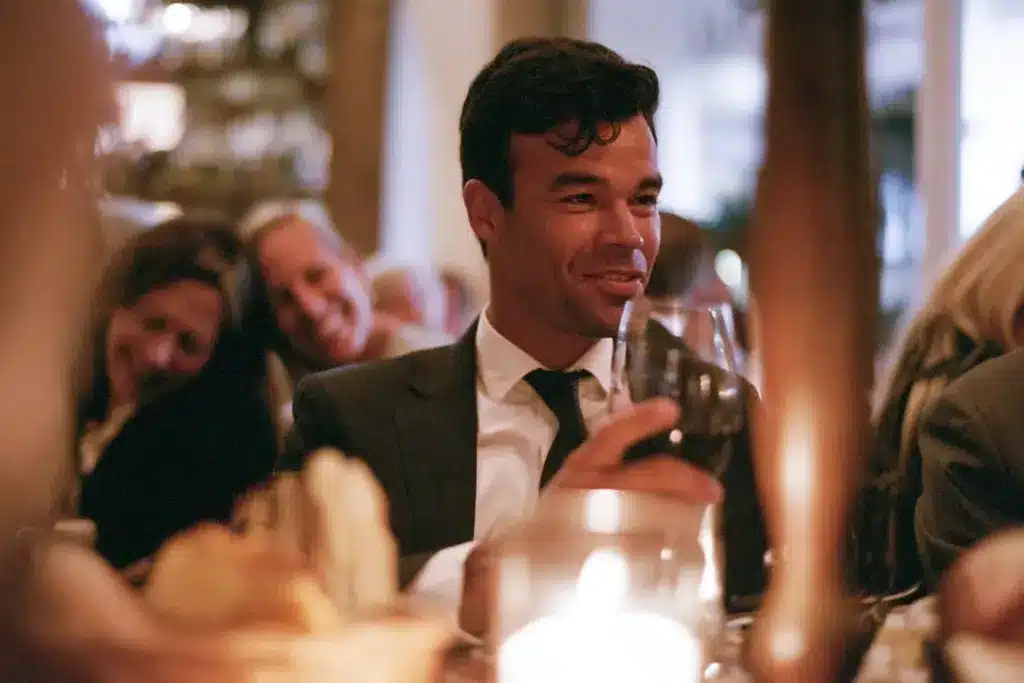 A professional man at an upscale business dinner on Las Olas, engaged on the surface but distant