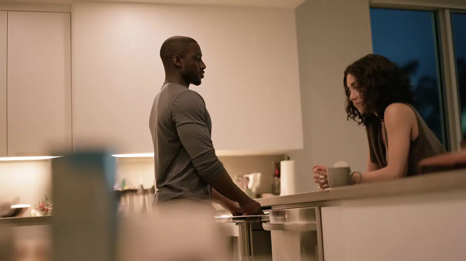 Married couple in their Fort Lauderdale kitchen at night, one partner needing quiet at the dishwasher and the other waiting to talk, a common moment in a neurodiverse relationship
