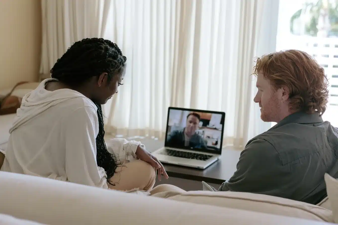 Couple sitting together on a sofa during an online couples therapy session from their South Florida home