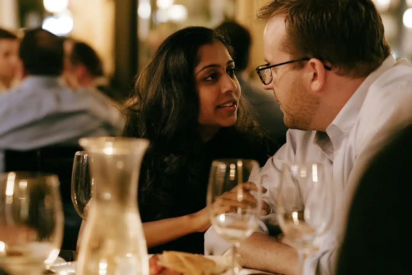 Couple at a quiet restaurant corner on Las Olas Boulevard, she reaches across the table as he listens