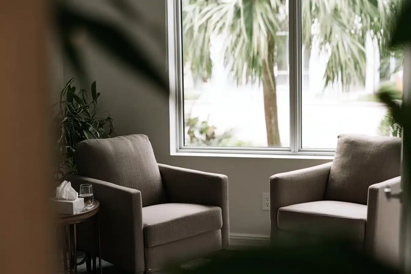 A modern therapy office in Fort Lauderdale with two armchairs, plants, and natural light